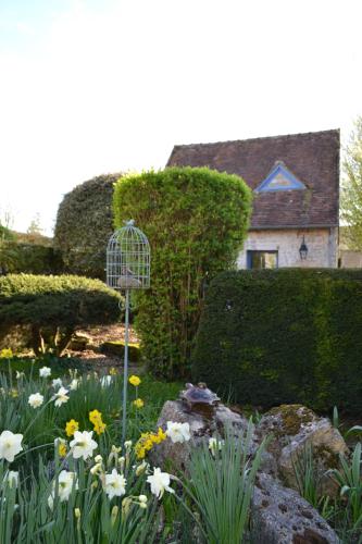 a garden with a bird cage and flowers at Gîte de charme proche du Zoo Beauval et Châteaux in Pontlevoy