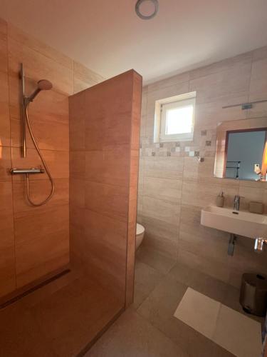 a bathroom with a shower and a toilet and a sink at Ubytovanie PLATAN in Bartošovce