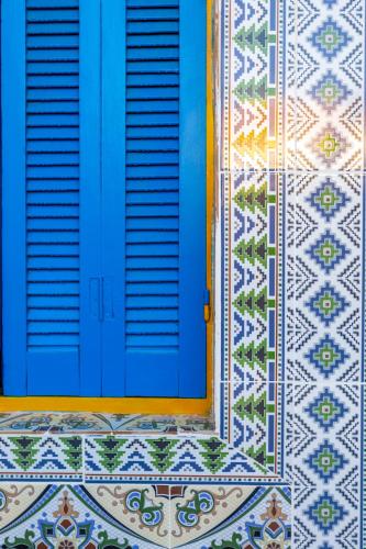 a blue door on a tiled building with a tile floor at BDar Stay Maison d'hôtes avec piscine et rooftop à Tozeur, à 10 min de la Médina in Tozeur