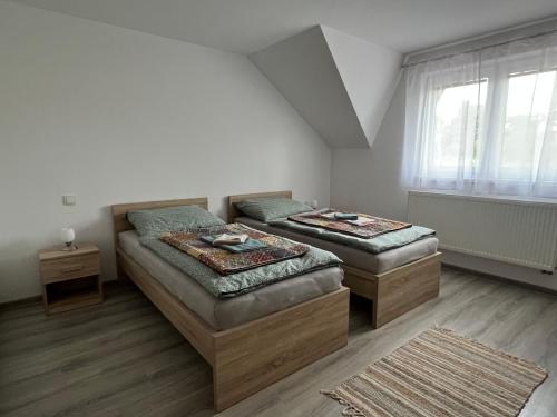 a bedroom with two beds and a window at Ubytovanie PLATAN in Bartošovce