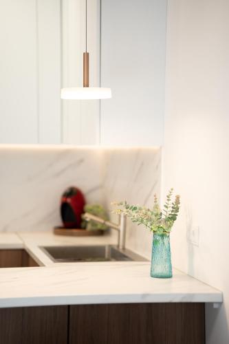 a blue vase sitting on a counter in a kitchen at Apartamentai Šilutė in Šilutė