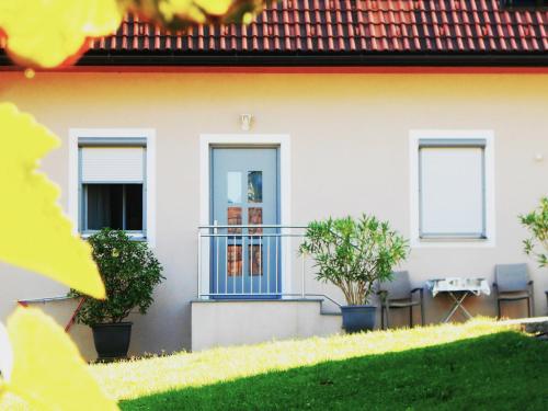 a house with a blue door and a balcony at Ferienwohnungen Karin am Seggauberg in Leibnitz