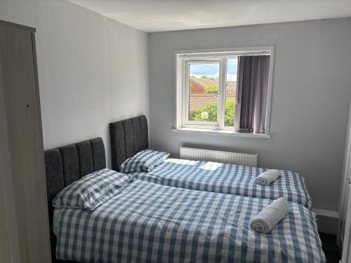 a bedroom with two beds and a window at Family and Contractor 4BR All En-suite Apt with Free WiFi and Parking in Warwick