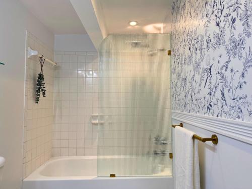 un bagno con vasca e doccia in vetro di The Hill House Your stay in DC Made Memorable a Washington