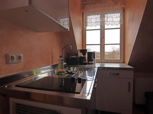 a kitchen with a sink and a stove and a window at Wohnung in Röbel am Müritzsee in Röbel