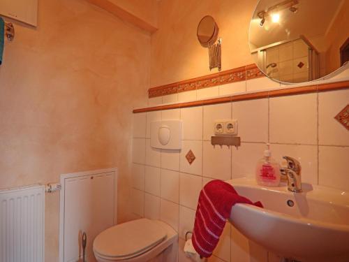a bathroom with a sink and a toilet and a mirror at Ferienwohnung Kogge im Zentrum von Röbel in Röbel