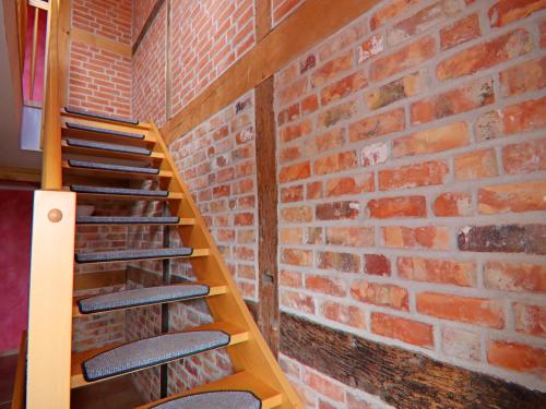 a room with a brick wall and a wooden staircase at Ferienwohnung Kogge im Zentrum von Röbel in Röbel