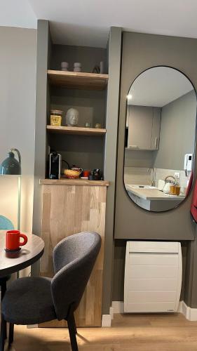 Cette chambre comprend un miroir, une chaise et un lavabo. dans l'établissement Évasion confort, à Paris