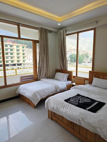 a bedroom with two beds and a large window at Beach Resort in Kalām