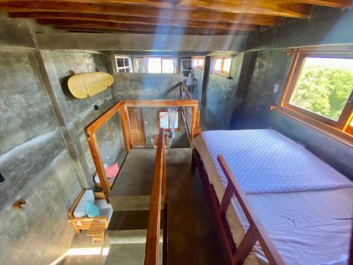 an overhead view of a small room with a bed and a surfboard at Hermanos Perdidos Surf in Las Tunas