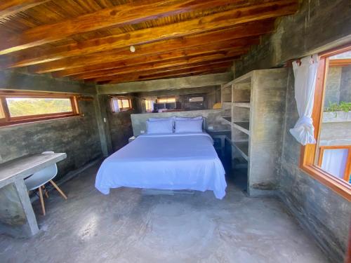 a bed in a small room with a wooden ceiling at Hermanos Perdidos Surf in Las Tunas