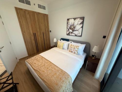 a bedroom with a large bed and a wooden door at 1 Bedroom in Maryah Island by Central Stay 1 min to Cleveland, Galleria Mall and ADGM in Abu Dhabi