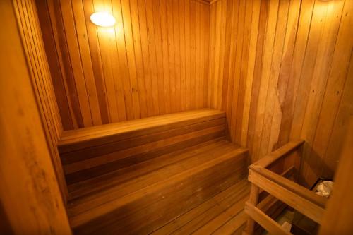a wooden sauna with a wooden bench in it at Araucária Lodge - 800 metros do Capivari in Campos do Jordão