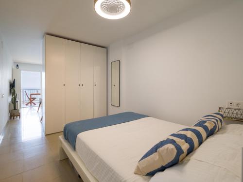 una camera da letto bianca con un letto e un armadio di Apartamento Primera línea playa a Las Palmas de Gran Canaria