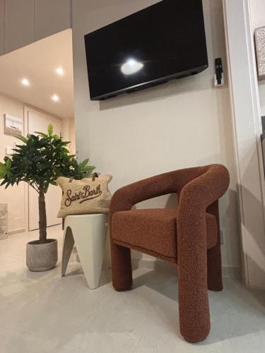 sala de estar con silla y TV en la pared en Casa Dolce Santa Margherita, en Santa Margherita Ligure