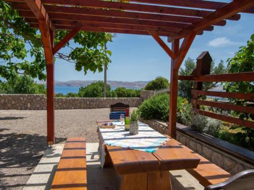 a wooden picnic table under a wooden pergola at Apartments Sanja in Karlobag