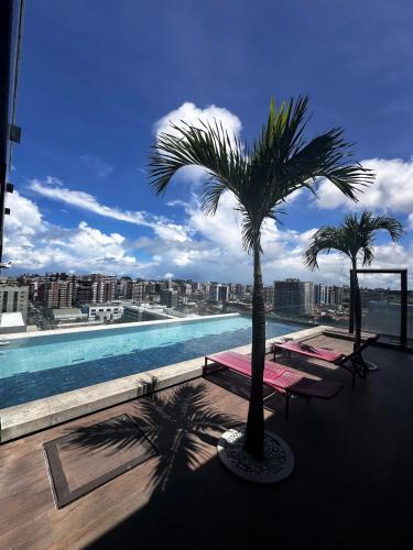 a swimming pool with two palm trees on a building at SKY Concept 306 in Maceió