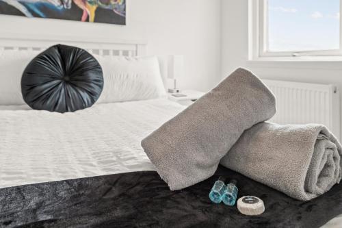 a bed with a blanket and two pairs of shoes at Ochil View 30 mins to Edinburgh and Glasgow in Falkirk