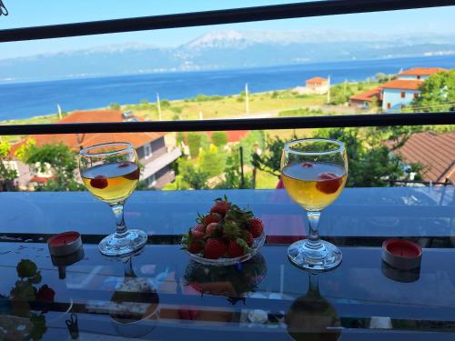 zwei Gläser Wein auf einem Tisch mit Aussicht in der Unterkunft Taku Villa Wonderful view of Lake Ohrid in Udënisht