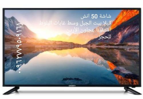 a television screen with a picture of a lake at فيلا بيت الجبل in Ishtafaynā