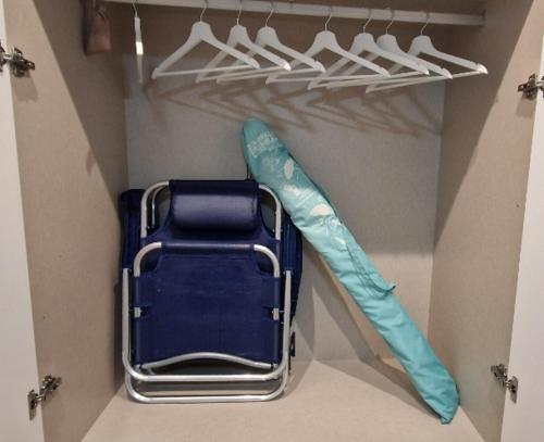 a closet with a suitcase and an umbrella and hangers at Brisa Marina Stay a unos pasos del mar in Valencia