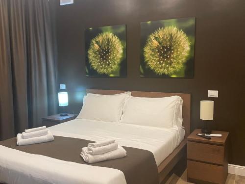 a bedroom with a bed with two pictures on the wall at COMÓ EXCLUSIVE in Aprilia