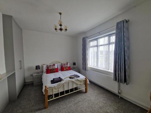 a bedroom with a bed with red pillows and a window at Castle View in Roscommon