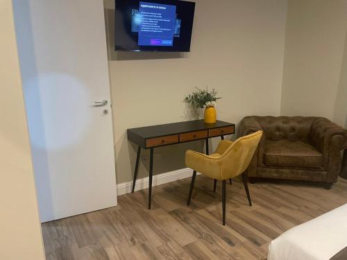 a room with a table and a couch and a television at COMÓ EXCLUSIVE in Aprilia