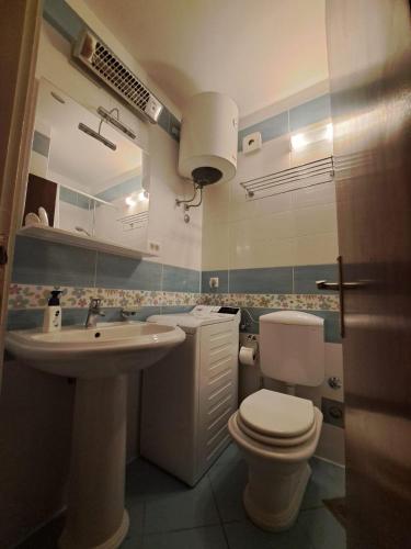 a bathroom with a white toilet and a sink at Apartments Lavica in Podstrana