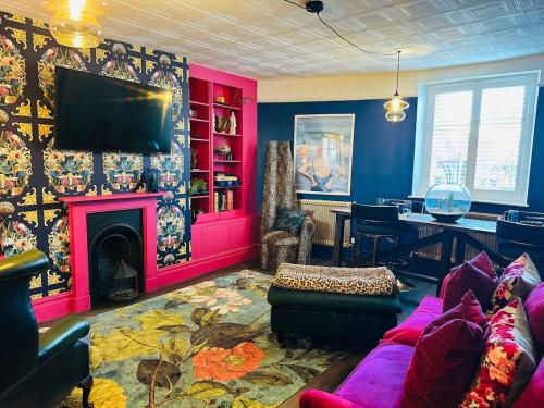 a living room with a couch and a fireplace at Bay escape beach apartment steps from the sea in Herne Bay