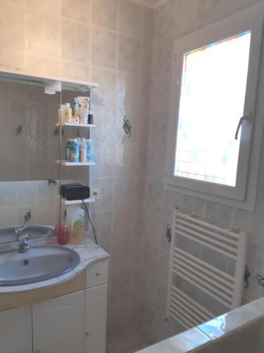 une salle de bain avec un lavabo et une fenêtre dans l'établissement villa 3 chambres 5 mn de la plage, à Alénya