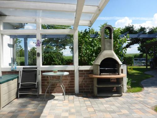 patio con forno all'aperto e tavolo di Behagliches Ferienhaus Mit Garten Und Terrasse a Rerik