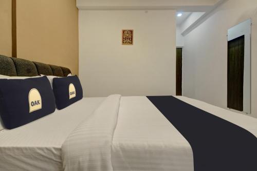 a bed with blue and white pillows on it at Super Collection O Grey House in Pune