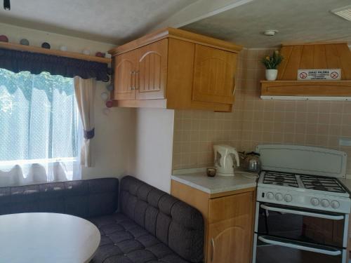a small kitchen with a couch and a stove at Domek nad Dunajcem in Gołkowice Dolne