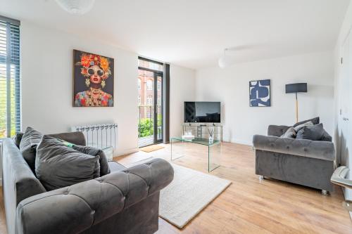 a living room with a couch and a television at Swift Host - Friars Quay - Riverside - Sleeps up to 8 - Free Parking - City Centre in Norwich