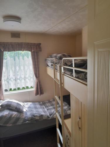 a room with two bunk beds and a window at Domek nad Dunajcem in Gołkowice Dolne