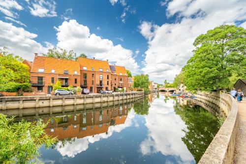 a river in a city with houses and buildings at Swift Host - Friars Quay - Riverside - Sleeps up to 8 - Free Parking - City Centre in Norwich