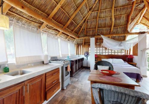 a kitchen with a sink and a room with a bed at Aventura Pacifico Boutique Suites & Villas in Bucerías