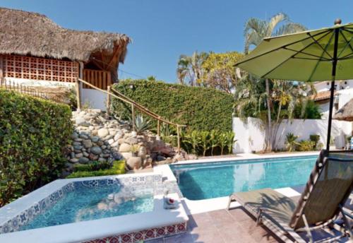 a swimming pool with a chair and an umbrella at Aventura Pacifico Boutique Suites & Villas in Bucerías