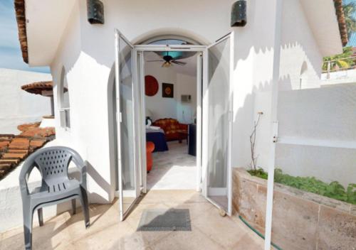 a white house with a chair in a hallway at Aventura Pacifico Boutique Suites & Villas in Bucerías