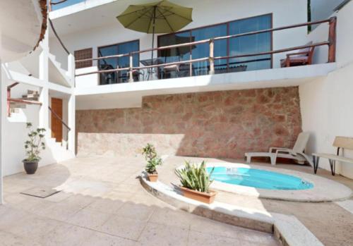 a patio with a swimming pool and a house at Aventura Pacifico Boutique Suites & Villas in Bucerías