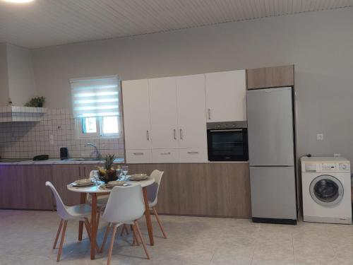 a kitchen with a table and chairs and a refrigerator at Sunny house in Kremasti