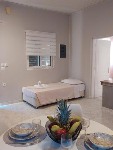 a room with a bed and a table with a bowl of fruit at Sunny house in Kremasti
