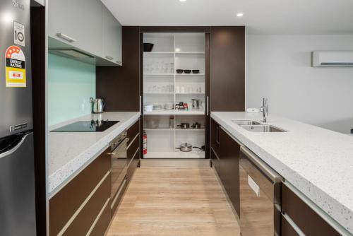 a kitchen with white counters and a refrigerator at Pohutukawa Apartment in Picton