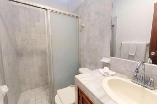 a bathroom with a shower and a sink and a toilet at Aventura Pacifico Boutique Suites & Villas in Bucerías