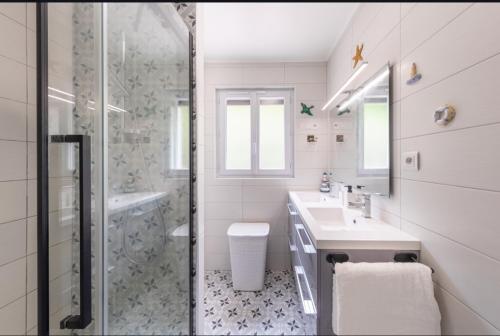 une salle de bain blanche avec une douche et un lavabo dans l'établissement Balcon du Tréport, au Tréport