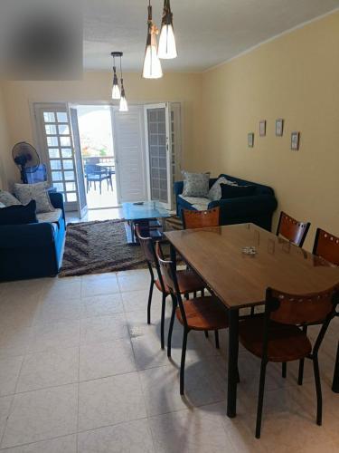 a living room with a wooden table and chairs at شاليه مارينا 6 in El Alamein