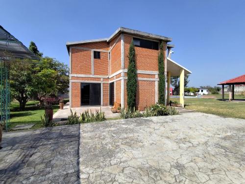 a brick house with a stone driveway in front of it at Casa de campo con alberca in Tlayecac