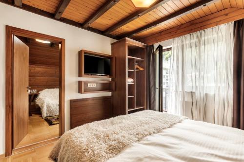 a bedroom with a bed and a tv and a window at Guest House The Hive in Bled