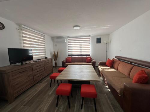 a living room with a couch and a table with red chairs at Gazdinstvo Đurović in Dobra Voda